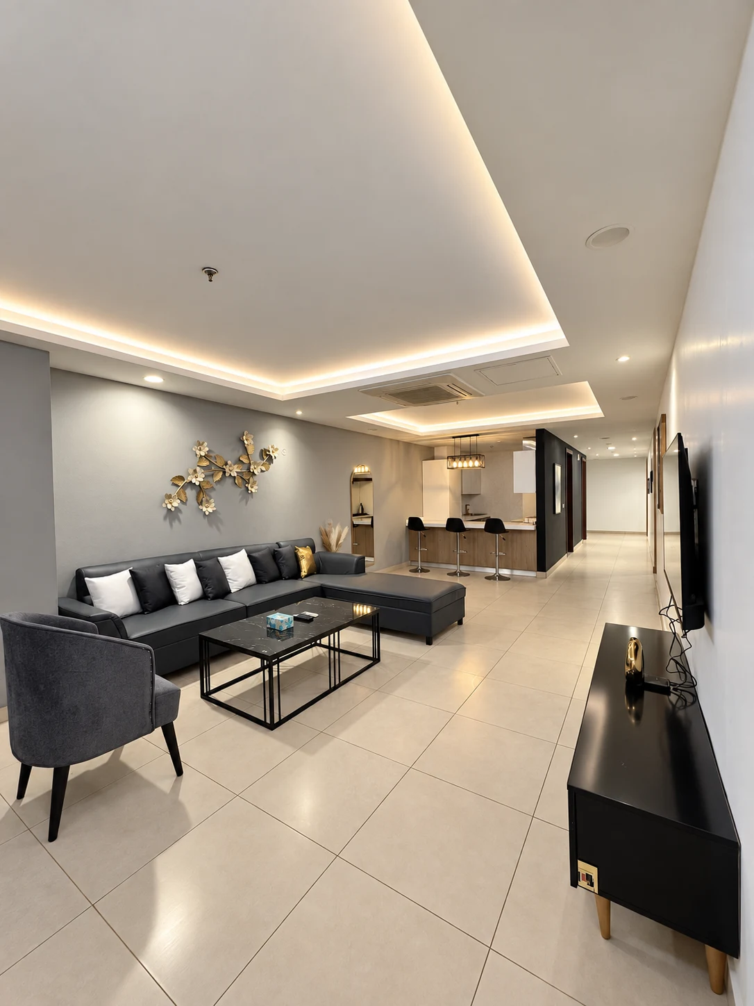 Open lounge with a dark sectional sofa, television and breakfast counter
