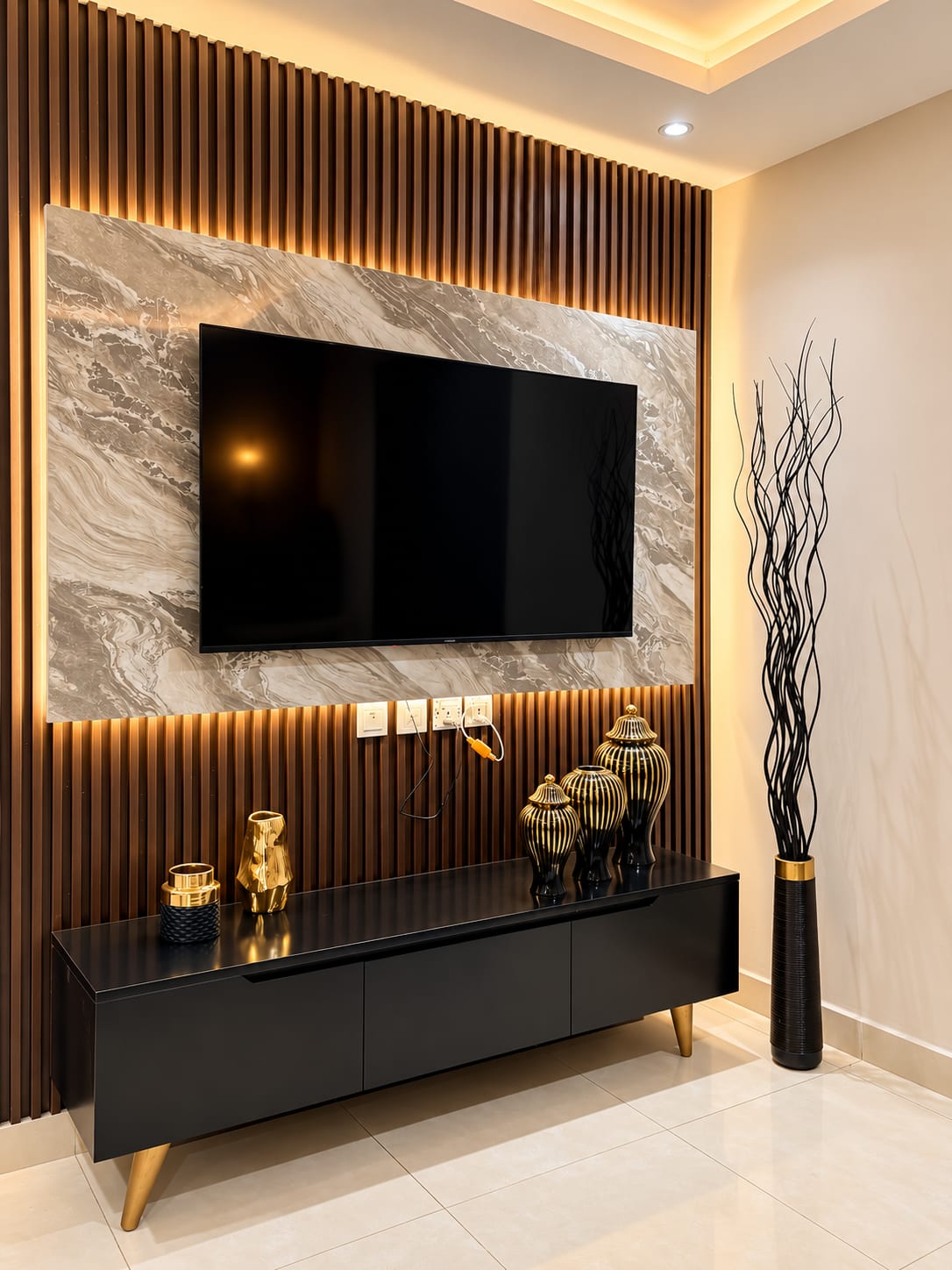 Wall-mounted television on a backlit stone-patterned panel above a black console