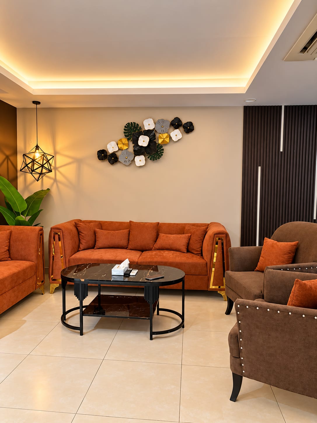Living room with rust-orange sofas, brown armchairs and a dark coffee table