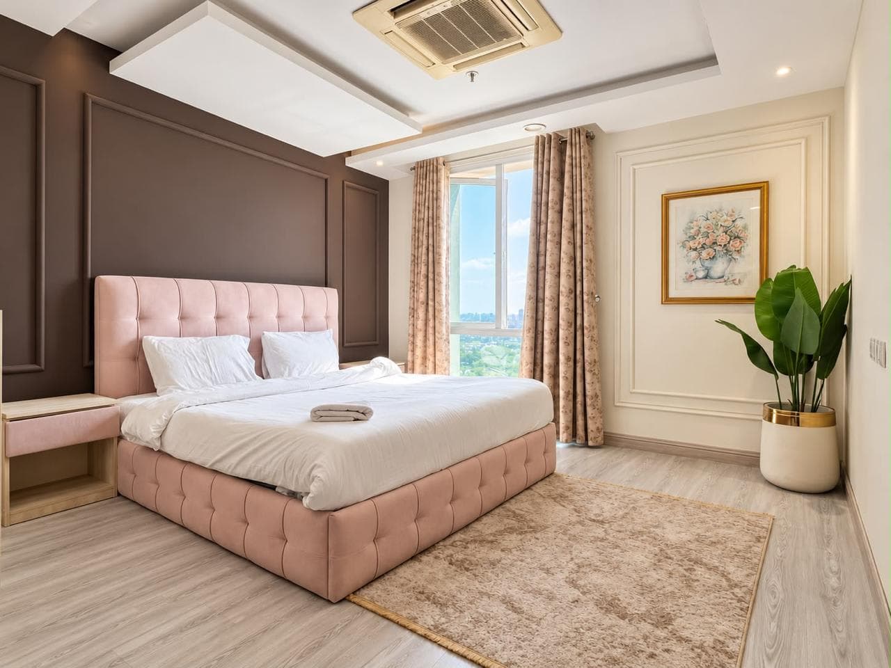 Bedroom with a blush upholstered bed, white bedding, a brown feature wall and patterned curtains