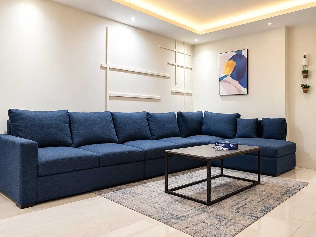 Navy sectional sofa around a black-framed coffee table beneath abstract artwork in the lounge