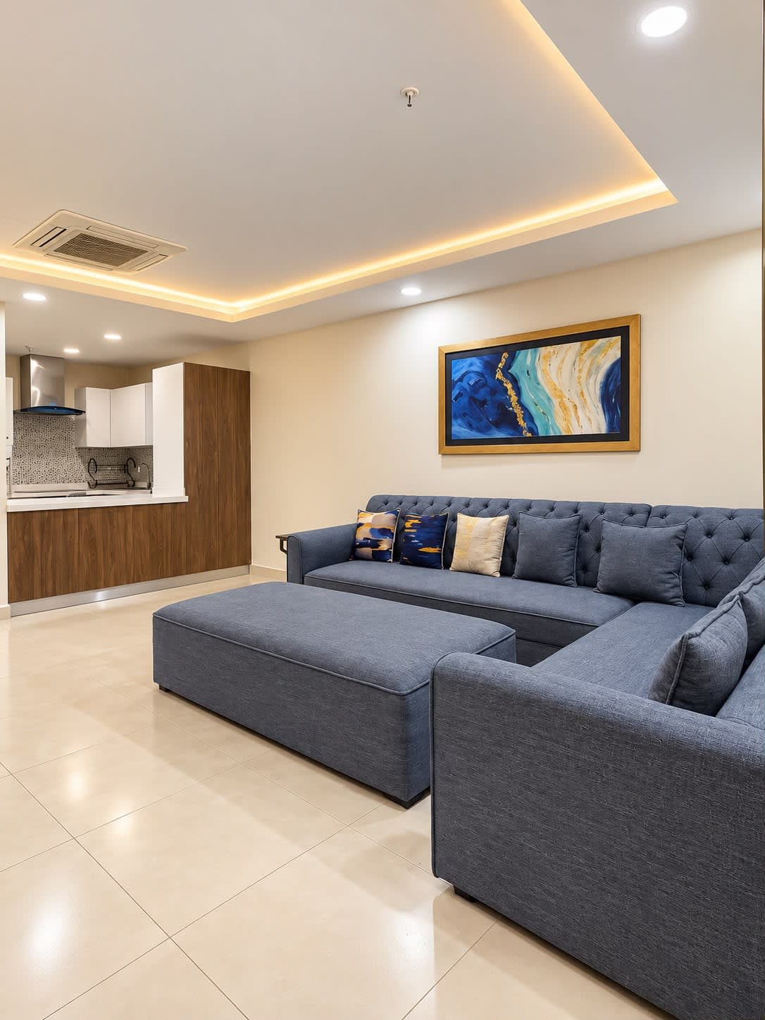 View across the lounge sofa and ottoman towards the kitchen serving opening